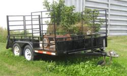 2003 Tandem axle trailer with surge brakes. This trailer is 12 feet by 6 feet wide. It has a unique ramp at the back that can open up to load stuff by forklift or drop down for an atv or lawnmower to drive up. The front has drive on /off ramp for an atv.
