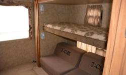 Beautiful 33 foot travel trailer with two slide outs. Sleeps 10 people and features a sleeper sofa, a booth dinette that has extendable seating, a walk around queen bed at the front and a wonderful back room with J Cube futon sofa, bunks and storage.