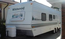 2001  27' Wildwood travel trailer.  Front queen bed. fold out couch, fold down table. rear bunks with full size bottom bunk. Sleeps 8. Tub with shower, large fridge, outside shower, awning, air conditioning, microwave, newer tires lots of storage.