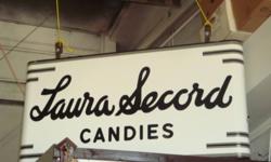 Posting for a friend, Please call the number below.
Huge Sign!
This is a very Rare antique 2 sided  porcelain Laura Secord Store hanging sign that hung over the sidewalk with original hanging brackets. It is around 6' long and 3' high. A must have for the