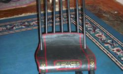 Antique rocker has been repainted black with decorative painting at top.