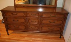 We have a 9 droor solid wood (probably chestnut) dresser bought in the mid 1960's from the Andrew Malcolm furniture manufacturing company.  The dresser has 9 drawers , and the mirror can be adjusted to suitable angles. The dresser and mirror are in very