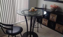 Elegant Bistro glass top table in excellent condition. Very stable with an espresso colour metal base. Includes 2 or 4 stools. Table measures 36'Â´ in diameter and 38'Â´ high. The stools are 24'Â´ high.Asking $290.00 for the set. Perfect for kitchenet or