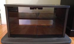 Black TV stand with smoked glass magnetic doors. Like new! Approximately 26" wide x 17" deep x 13.5" high