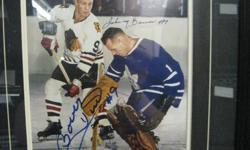 This unique frame features a Bobby Hull and Johnny Bower dual-signed 16" x 20" game photo with a laser etched description. This item has a black frame and includes a decorative v-groove. Perfect for any home or office and a unique addition to any hockey