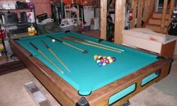 8 foot Brunswick pool table with ball return. Comes with 4 cues, rake, set of balls and a wall mounted cue holder.