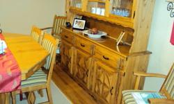 Made of solid oak. 6 chairs 2 with arm rests. Table extends with 2 leaf extension.Hutch has glass insert doors with gold trim. Very good condition.