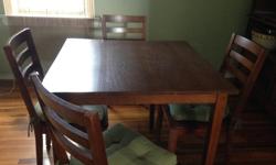Oak finish. Table is 1 square meter in size with 4 solid chairs and cushions. Excellent condition.