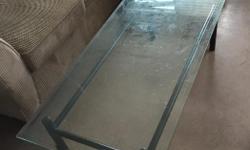 50" x 22" coffee table with thick glass top and black metal frame.