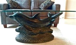 Dolphin sculpture pedestal holds an oval glass top, beautiful unique addition to you living room.