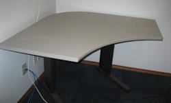 This corner table can be adjusted in height. It is grey in color. Excellent condition. We no longer require this table.. Call during regular office hours .. 403.388.2923.