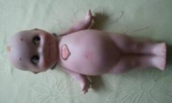 7 " Kewpie Doll designed by Rose O'Neill, German Bisque. Kewpie signed on foot, Jointed Arm. Heart Orginal sticker on front, Design Patened sticker on back. Offers.