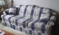 Blue and grey matching couch and love seat with four pillows.