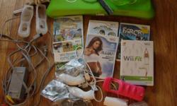 Nintendo Wii for sale, with 2 controllers with rechargable batteries, 2 nunchucks, charging stand, balance board with green cover & extra feet, 2 gel controller covers, 1 foam nerf controller cover, all original manuals and Chicken Shoot, Tomb Raider,