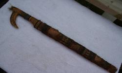 Hand painted sheath adorned with hair and fur. It has intricate patterning on the blade with four brass plugs. Careful with this one - it cuts paper. Blade is 16 inches long and the overall length in sheath is 23.5 inches. Sorry, the little knife is
