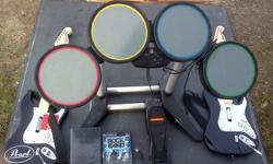 Rock Band comes with one drum set (wired) with 2 drum sticks, 2 wireless guitars with an adapter, an rock band one and the track pack.