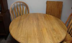 42 inch round oak table with 18 inch leaf. Comes with 5 chairs and 2 are captains chairs. Just reduced.