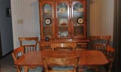 Solid maple dining set.  Table with two leaves and six chairs.  Matching sideboard with 4 glass upper doors and three drawers and closed storage below.  Matching corner display unit, glass doors, one drawer and closed storage on bottom.  Must be sold as