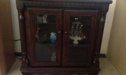 Beautiful darkly stained maple cabinet. Glass doors and shelves. An elegant statement piece and perfect for displaying those treasured items. Call or text.