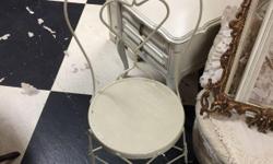 Adorable single ice cream parlor chair in old cream paint. Features twisted wrought iron frame with heart shaped back and wood seat. Perfect little chair for a front porch or balcony. Great with shabby chic and country decor. Available at Impressa Home on